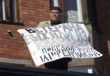 Пикет в День Победы: «Ветерана выжили из квартиры. С Победой тебя, Парфенчиков!» Блогер Алексей Трунов провел пикет в День Победы на крыше "Невского пассажа". Фото: Иван Печенкин